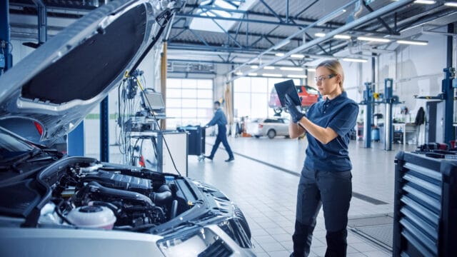 Preventative Maintenance Services, woman in auto repair shop with tablet
